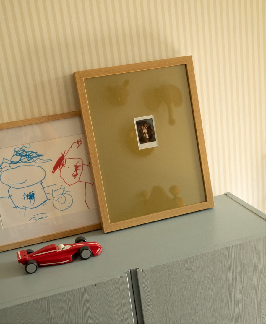 Polaroid Instax mini in een olijfgroene passe-partout, thuis bij Charlotte Doets